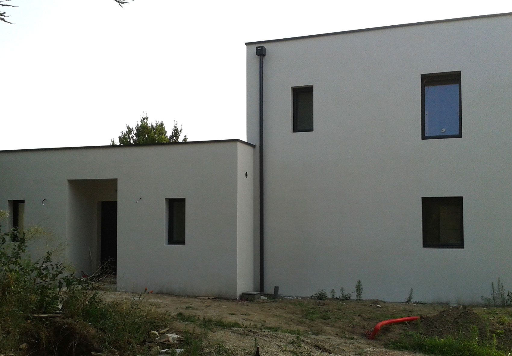 Construction d’une maison autour d’une piscine existante à Taluyer.